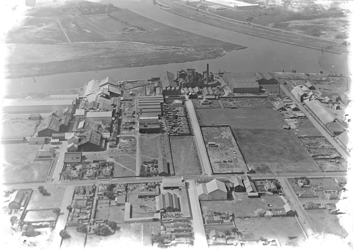 Looking north over Yarra River at Fishermans Bend, factories in foreground including two buildings of General Motors Holden, Port Melbourne (1927–38)