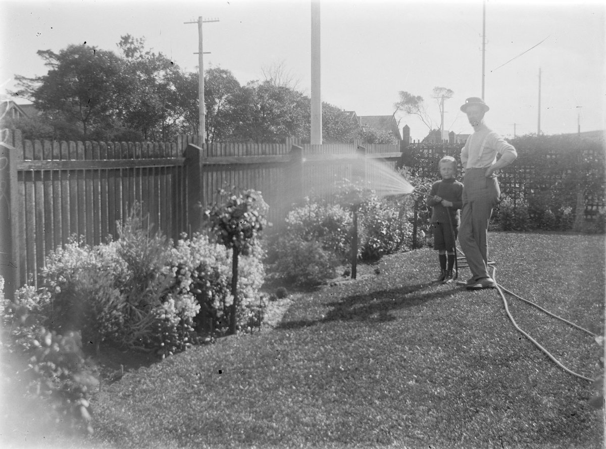 [Middle-aged man and young boy] watering the garden, Elsternwick (1900–15)