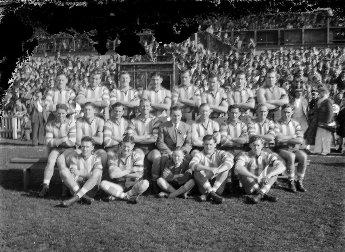 North Melbourne (VFL) football team in front of a grandstand (c. 1949)