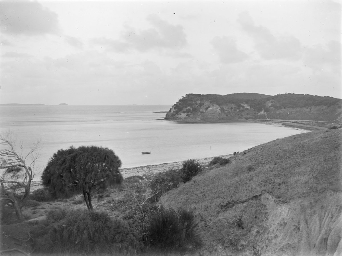 View of Port Phillip Bay with a wooden rowboat on calm water (1914–18)