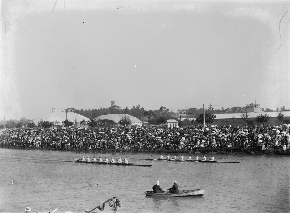 Two sculls on river with large crowd packing the bank of the river - Henley on Yarra, Melbourne, Victoria, Yarra River (1900–14)