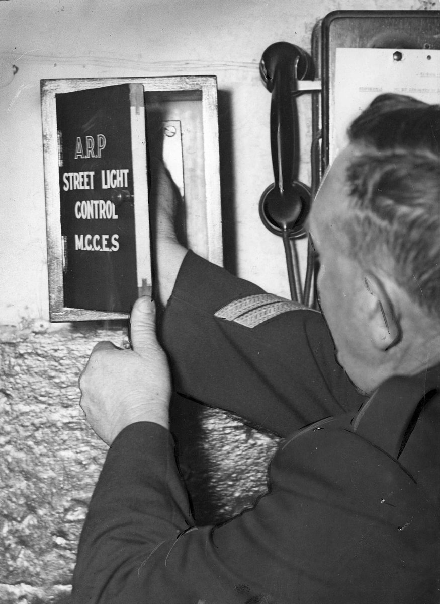 Police officer switching off city lights at Bourke St. West Police Station, Melbourne City (c. 1941)