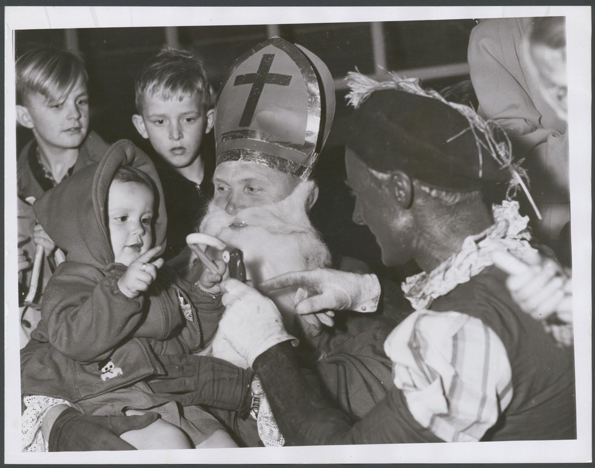 Dutch children who arrived from, Holland by K.L.M. Skymaster at Essendon had a nice surprise when they were met by Saint Nicholas ... Black Peter. Little Sonia Van Derwiok from Leiderdorp, Holland (1952)
