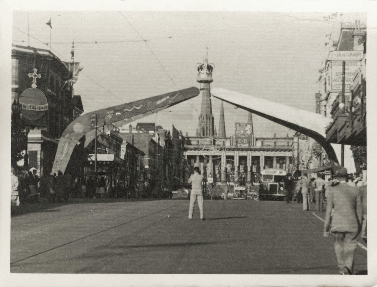 Arch of boomerangs, topped with a crown, spanning Bourke Street Melbourne, looking towards Spring Street and Parliamentary Buildings, Melbourne City (1930–50)