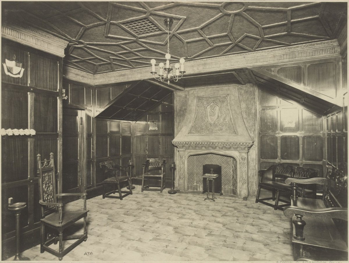 Interior of dark panelled smoking room with large fireplace and pseudo medieval chairs and settle in the State Theatre Melbourne (1929)