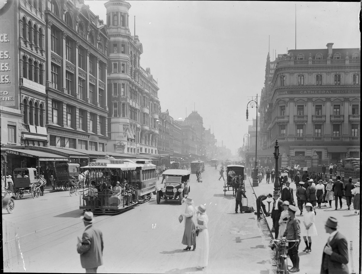 Swanston Street, Melbourne, looking north, from beyond Flinders Street, showing cable trams, people, cars and horse drawn vehicles, Melbourne City (1910–20)