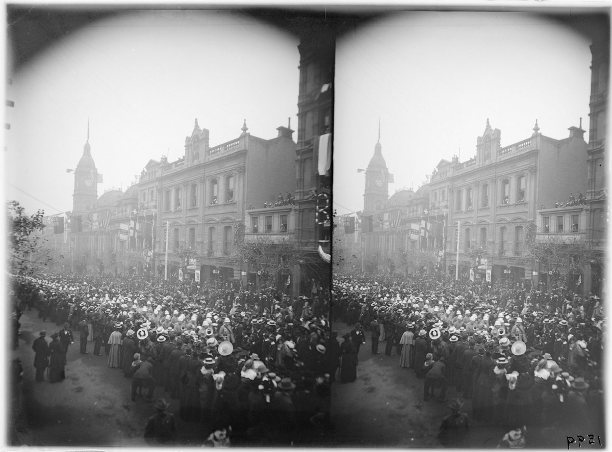 Crowds in Collins Street near Atheneum Theatre, flags across road, Melbourne City (1890–1910)