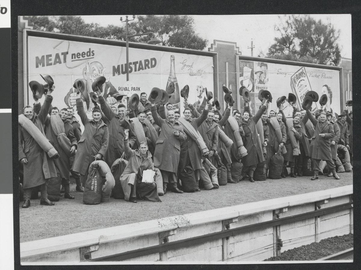 [Crowd of troops at Royal Park railway station, waving their hats, Parkville (c. 1940)