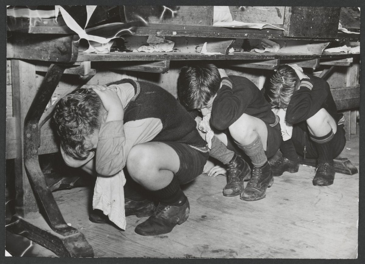Brighton Technical School Boys crouch under their desks (c. 1942)