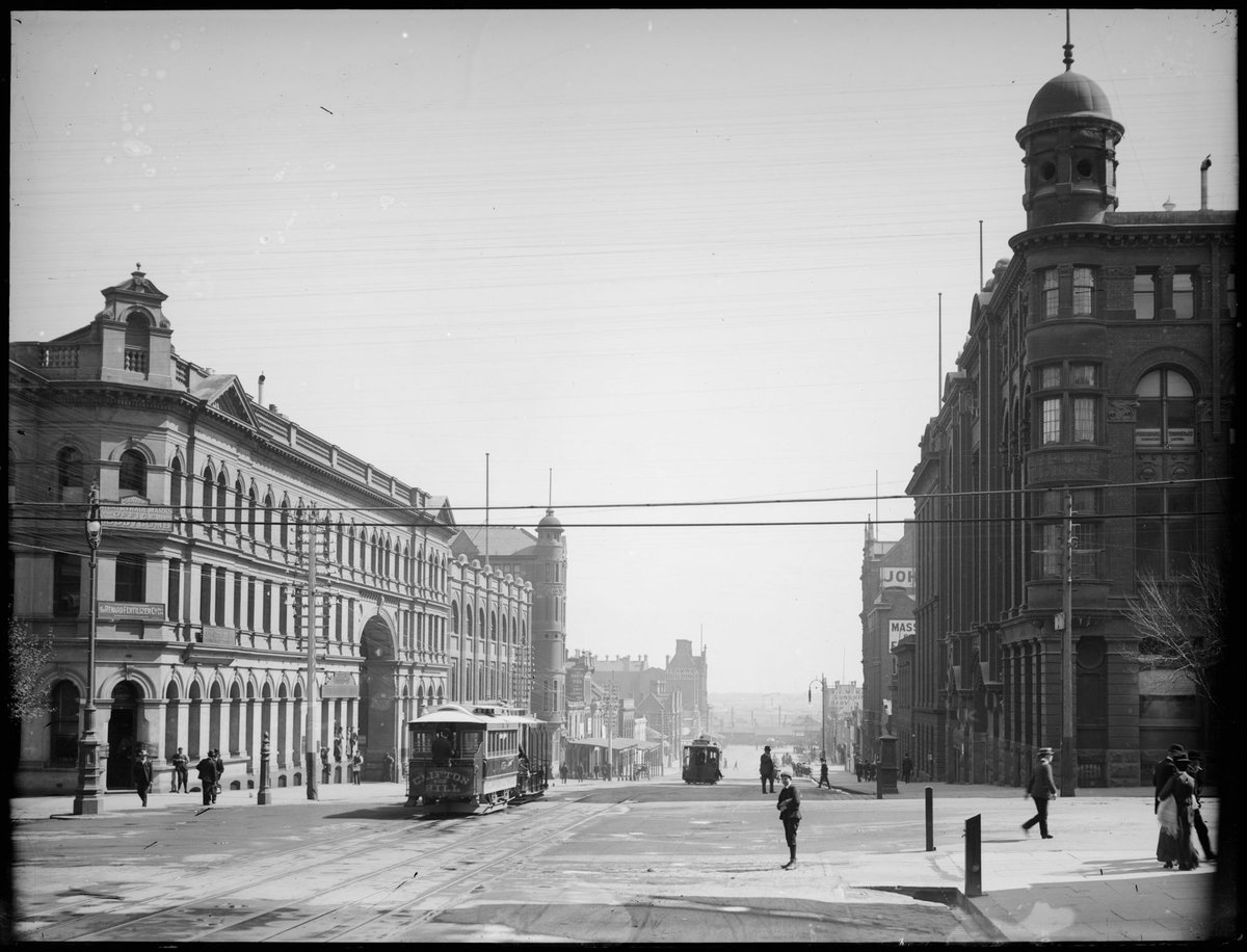 [Looking along street with trams and pedestrians, possibly the corner of William and Bourke Streets, Melbourne], Melbourne City (1891–1914)