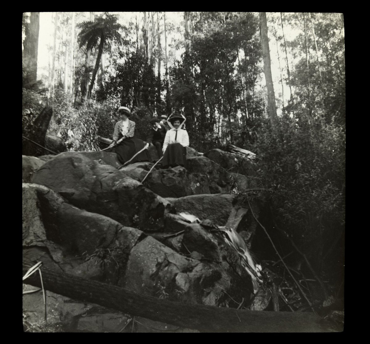 [Wardell] Girls looking down over rocks - near Yarra River ? (1910–20)