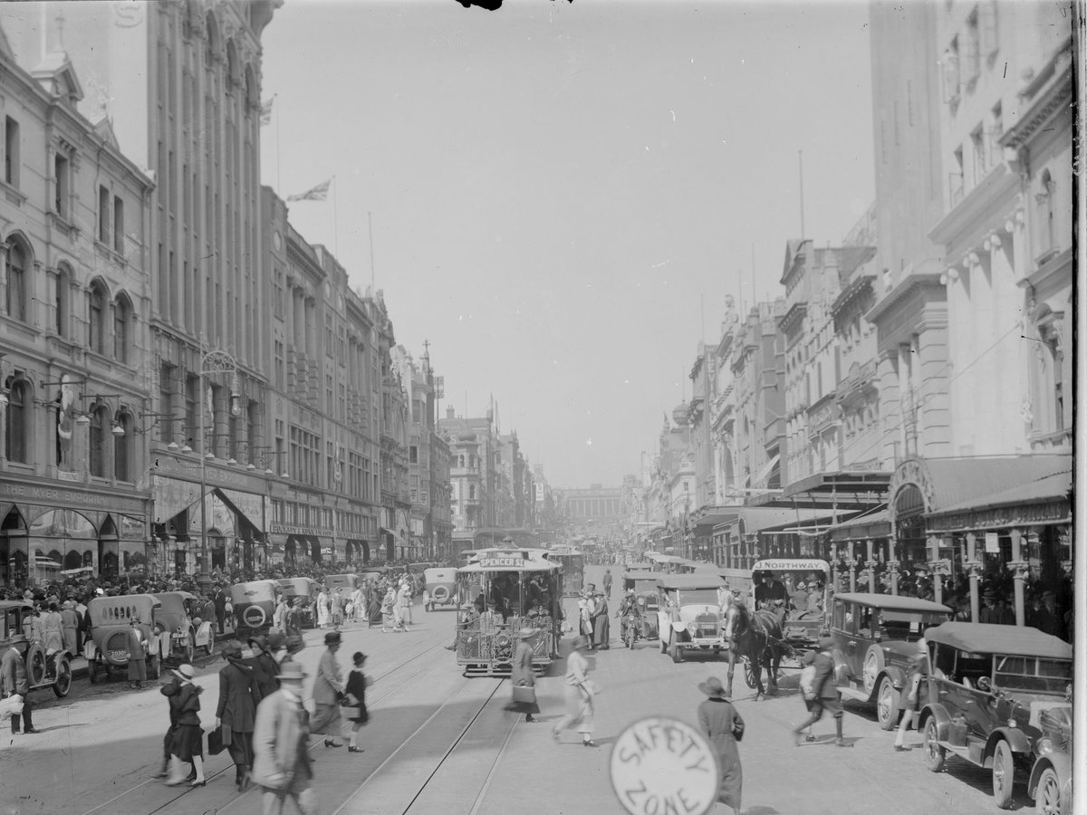 Bourke Street, Melbourne, looking east from above Elizabeth Street, showing Myer Emporium, Buckley & Nunn Ltd., cable trams, pedestrians, parked cars and safety zone in roadway, Melbourne City (1910–20)