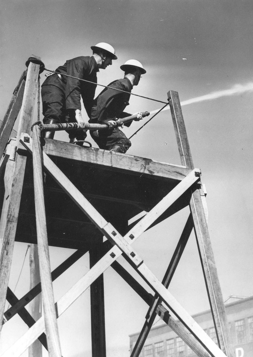 Two Footscray Auxiliary Firemen on platform using firehose (1939–45)