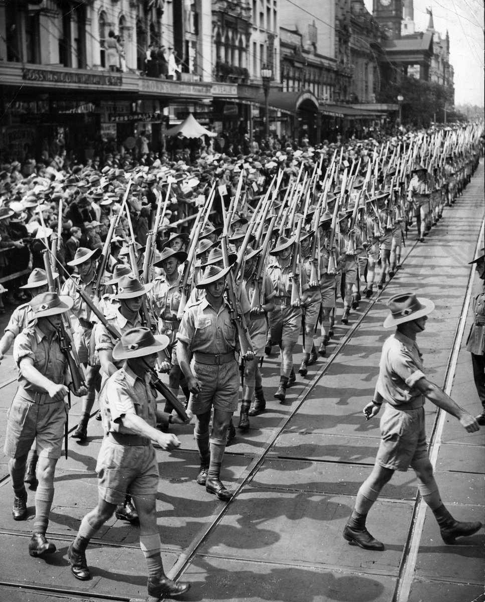 Marching troops turn from Swanston Street into Bourke Street, Melbourne City (c. 1941)