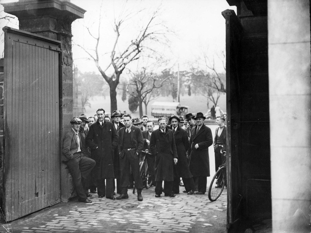 Men gathered outside Victoria Barracks in St. Kilda Road, Melbourne with a truck passing, Melbourne City (c. 1939)