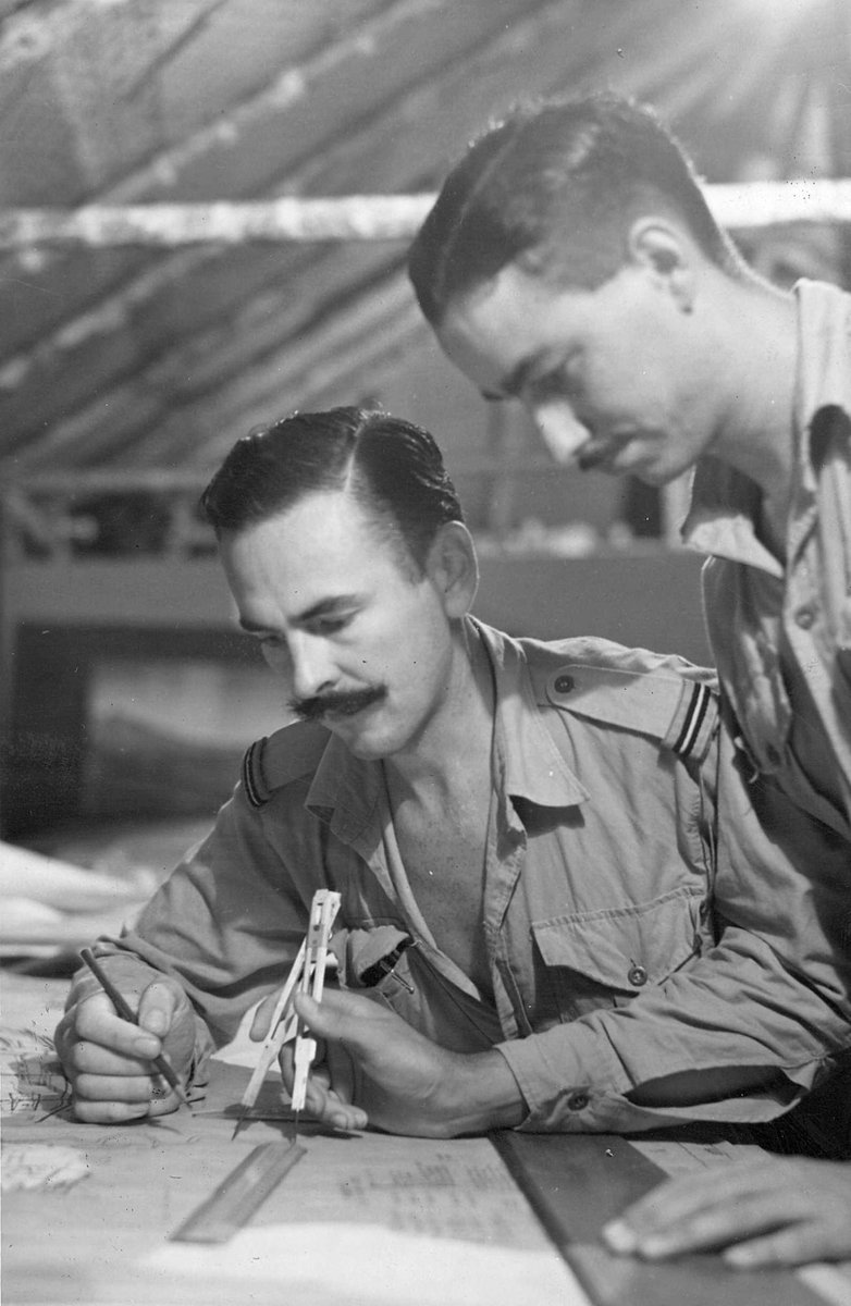 F/O. M. E. Collard of Brighton, Vic. and LAC D. W. Sinclair of West End, Q'ld, working in the drawing office of a RAAF survey unit at Aitape (c. 1944)