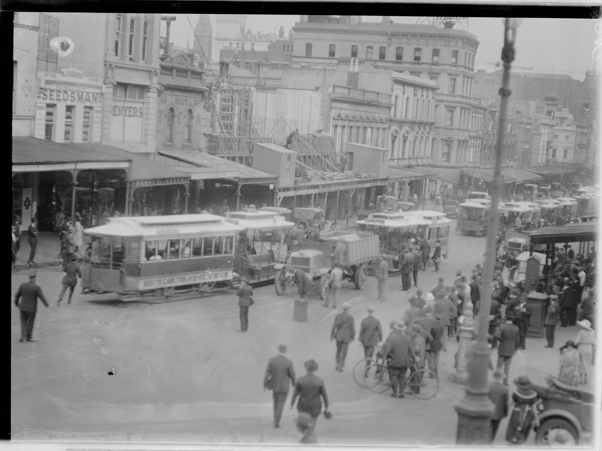 Street scene showing trams including one reading "North Carlton, South Melbourne", crowd watching from footpath, Carlton North (1902–20)