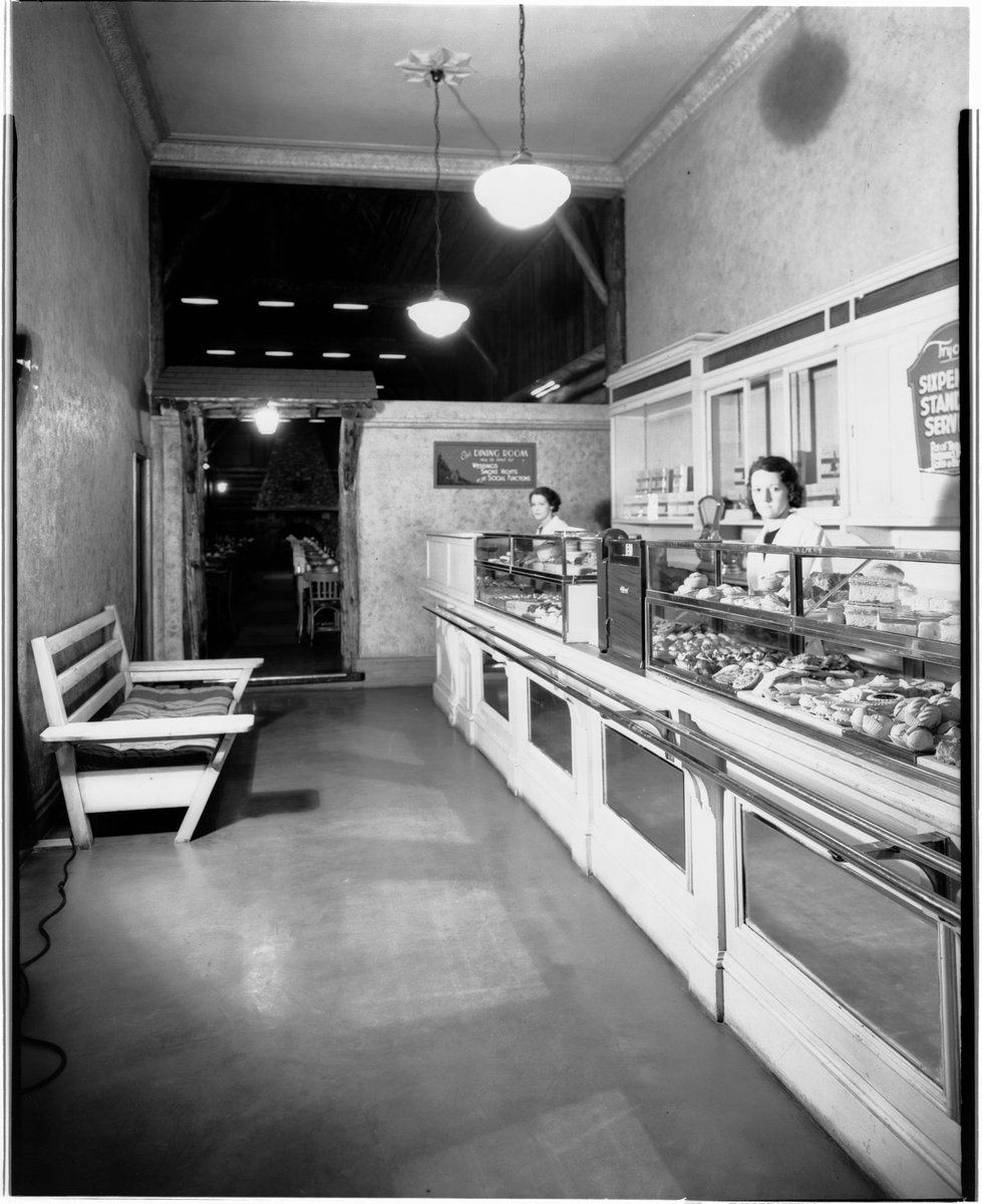 Interior of large restaurant opposite Melbourne Town Hall, Swanston Street, showing waitresses behind food displayed at counter, Melbourne City (1940s)