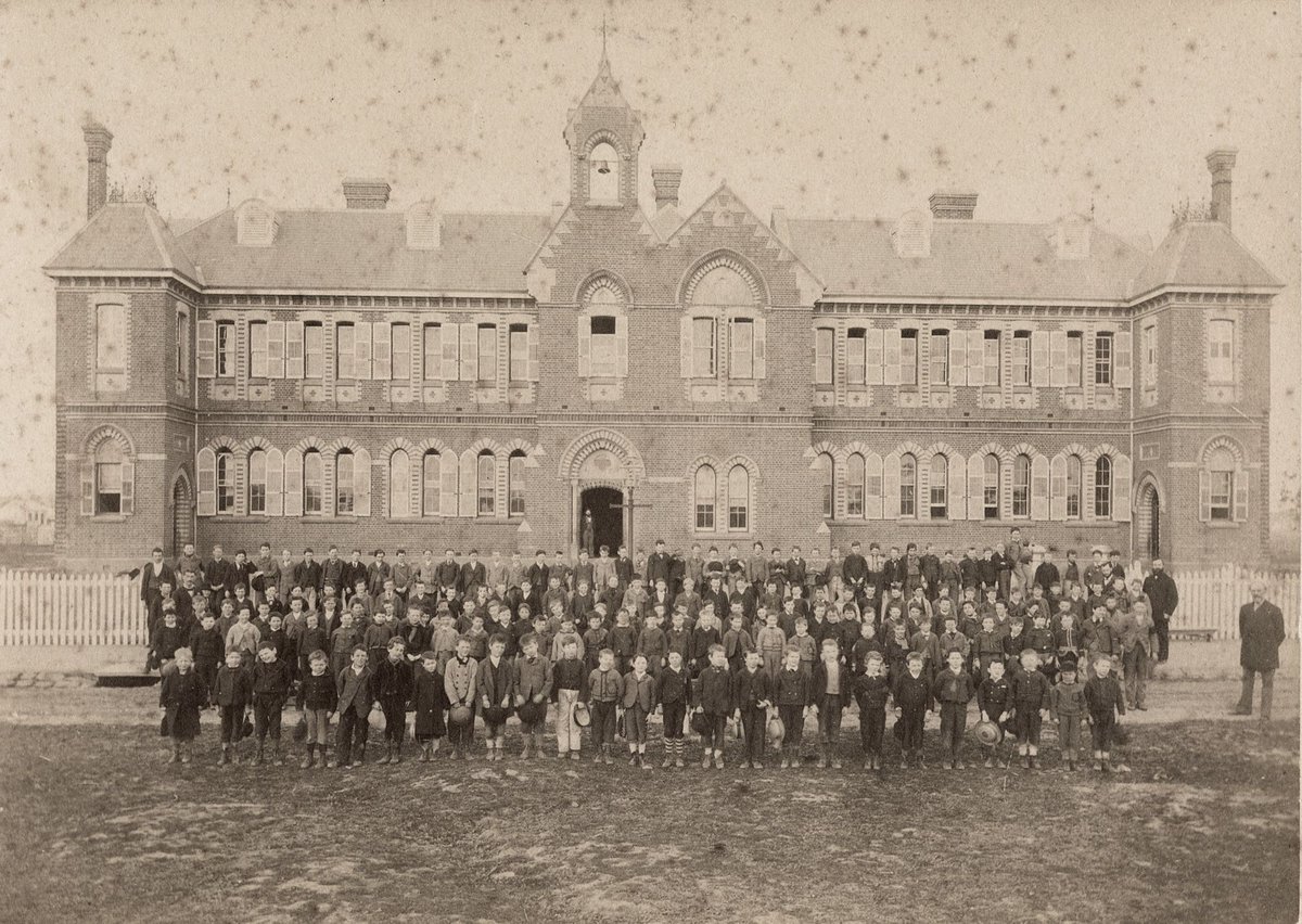 Male pupils and their teachers outside their school, Richmond Central State School, Gleadell Street, Richmond (1885–91)