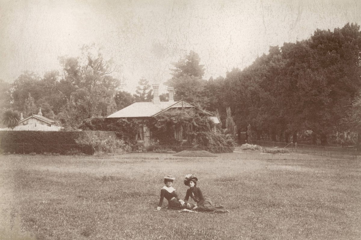 Two women seated on ground, possibly outside Melbourne Botanic Gardens, Melbourne City (1890–1900)