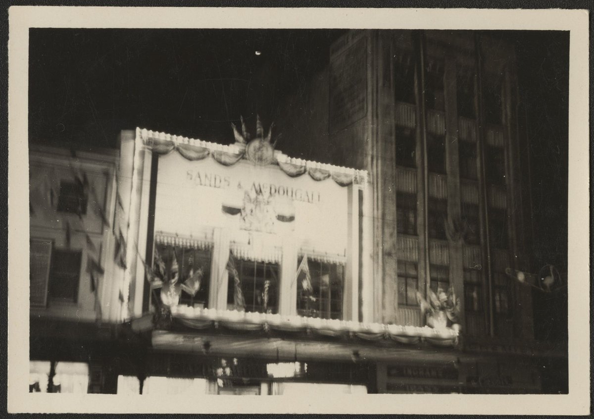 Floodlit decorated facade of Sands & McDougall printers and lithographers in Spencer Street, Melbourne, Melbourne City (1954)