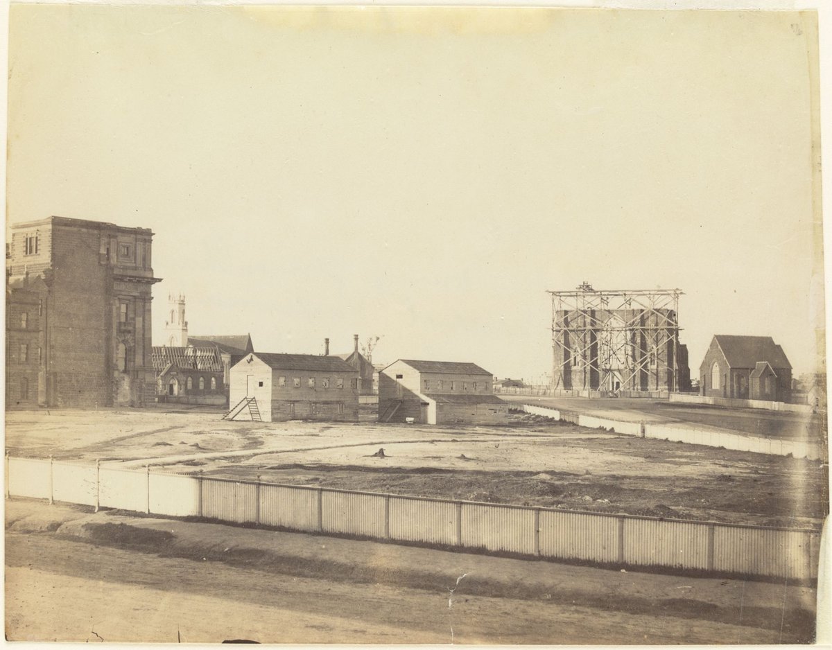 Eastern Hill. View of German Church, St. Patrick's Cathedral, Parliament House St. Peter's Church. Schools being newly roofed from Spring St [Melbourne], East Melbourne (1861)