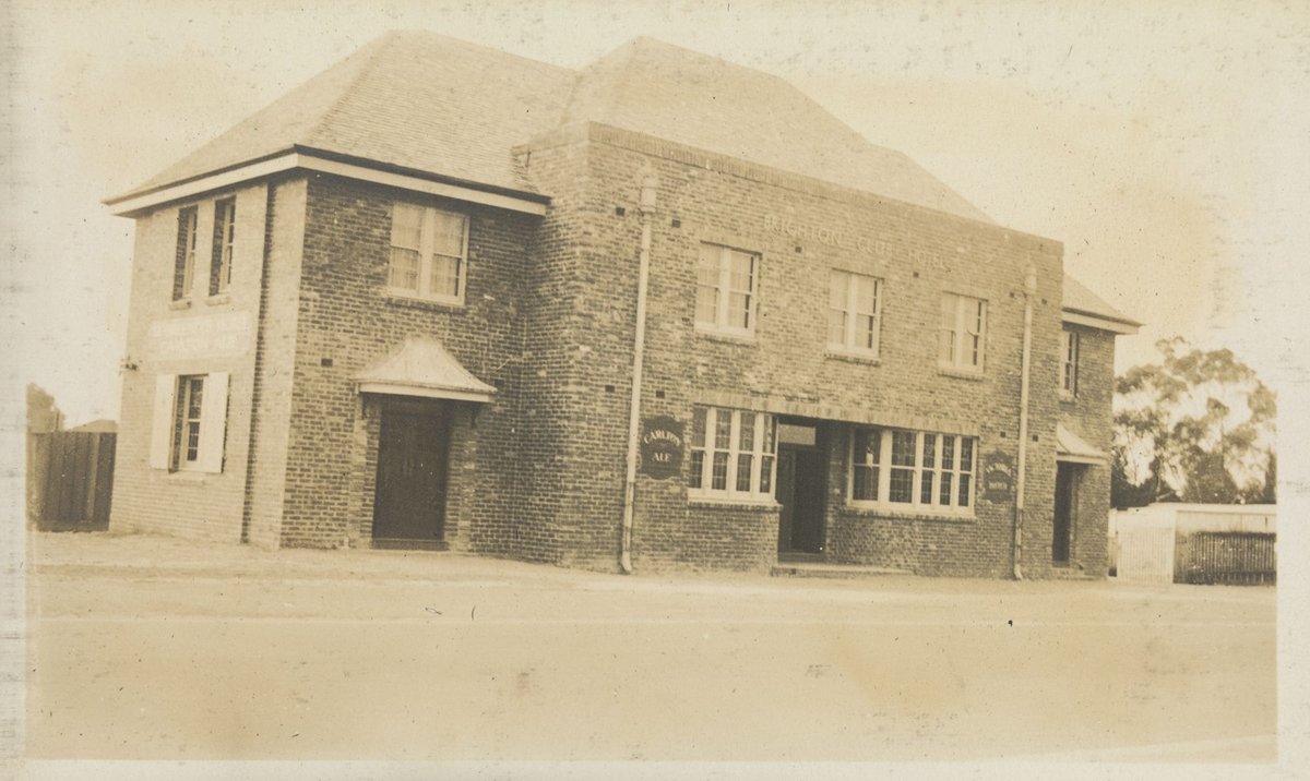 Double storey brick building with advertising for Carlton Ale, probably a hotel (1934–51)