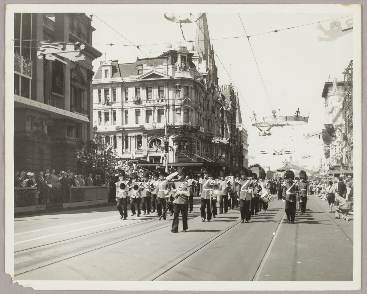 Marching band at corner of Collins and Swanston Street, Melbourne City (1954)
