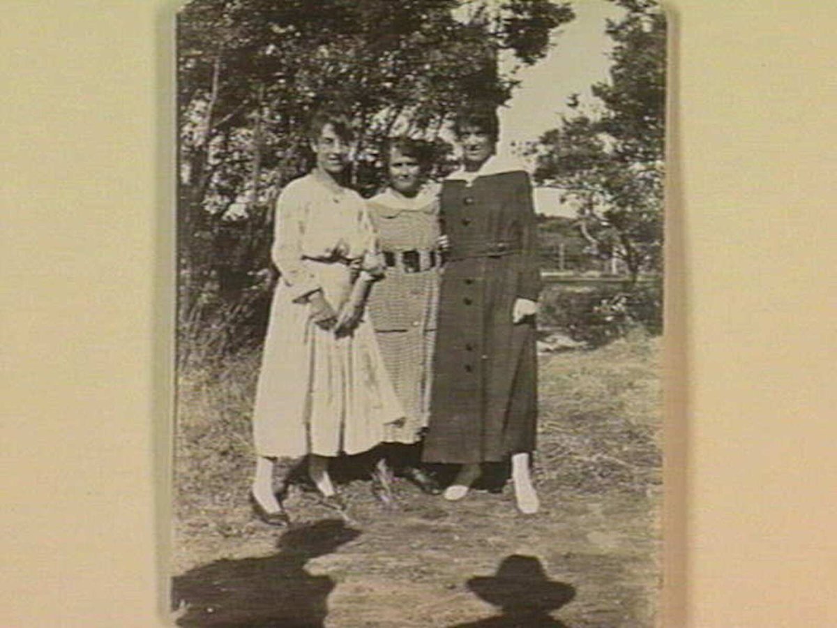 Photo of three women with arms linked, standing in the bush, Aspendale (c. 1917)