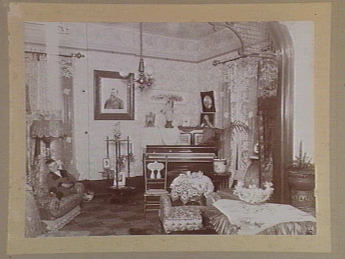 Interior view of Englefield, 69 Mathoura Road, Toorak, with young boy seated on couch (1899)