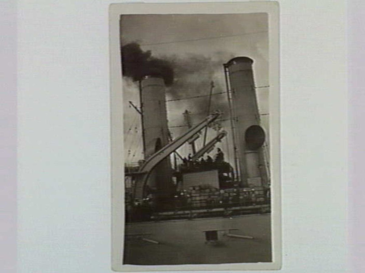 Coaling one of the American Cruisers - Station Pier, Port Melbourne. Coal Hulk along side. Dirty Trimmers with ships band playing. 1920's