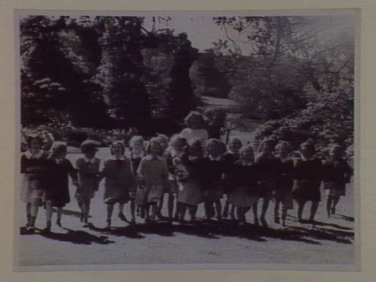 Mrs Manders with children from Melbourne Grammar in Botanical Gardens, South Yarra (1910–20)