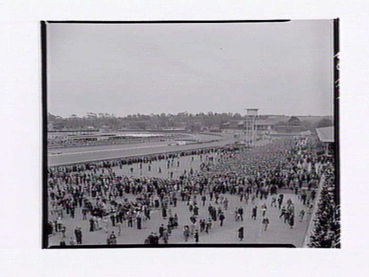 Bird's-eye view of Flemington Racecourse, racetrack in distance, on Melbourne Cup Day (1949)
