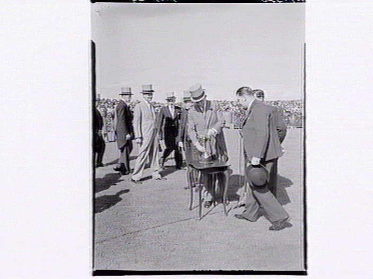 [Officials displaying the Melbourne Cup trophy at Flemington Racecourse (1949)