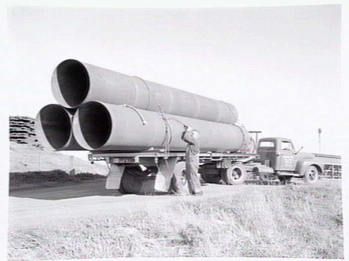 A man securing tubes on the back of a truck belonging to Humes Ltd, Dynon Road, Footscray (c. 1954)