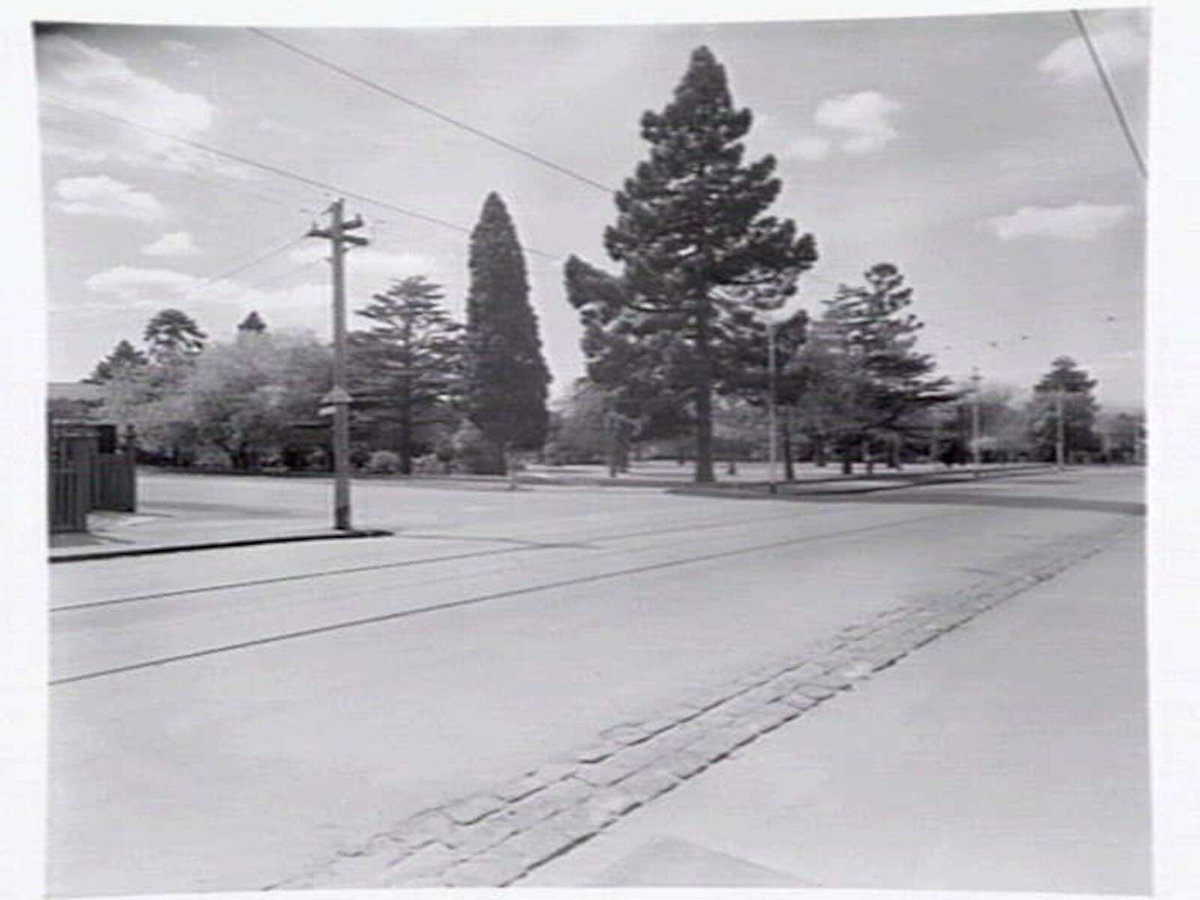 View down High Street, Malvern, the Malvern public gardens, and State School on corner of High Street and Spring Road, Malvern (c. 1950)