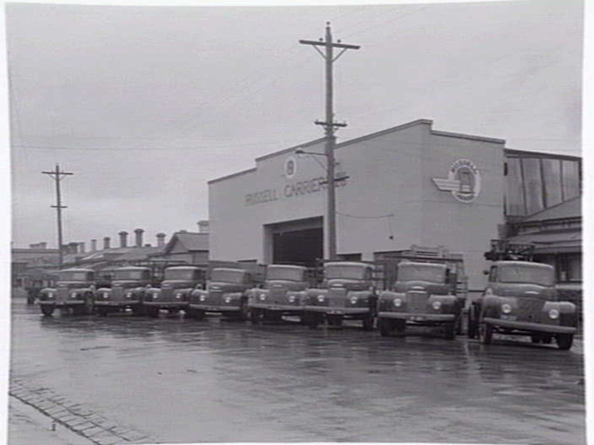 Exterior, Russell Carriers, Pty. Ltd., 235 Ross Street, Port Melbourne, with fleet of trucks outside (c. 1952)