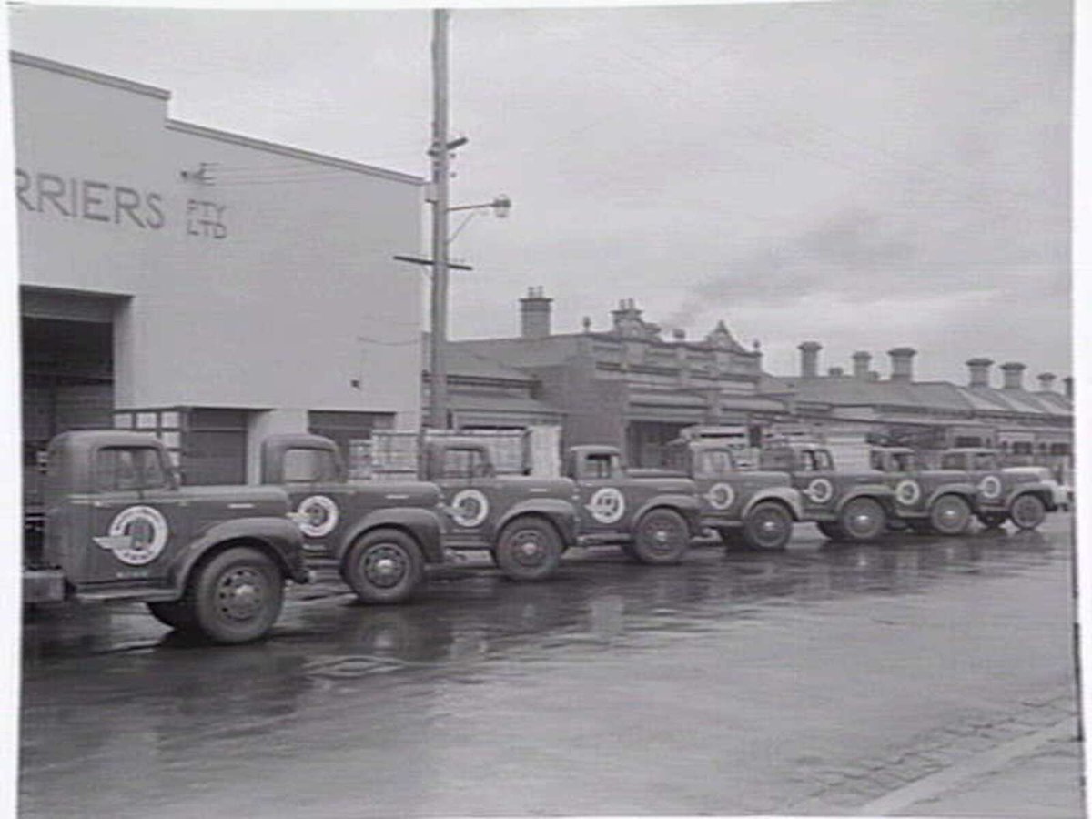 Exterior, Russell Carriers, Pty. Ltd., 235 Ross Street, Port Melbourne, with fleet of trucks outside (c. 1952)