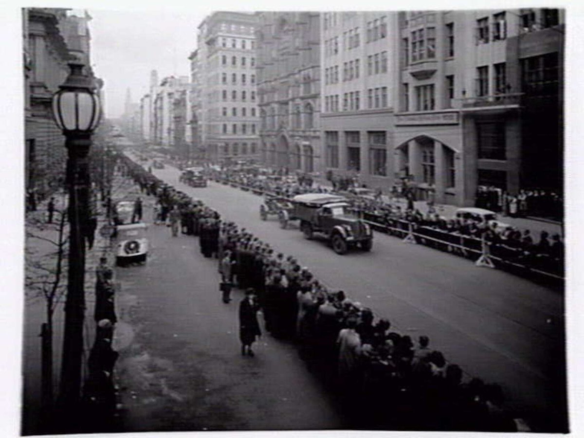 Military procession including tanks and trucks along Collins Street, Melbourne, Melbourne City (c. 1943)