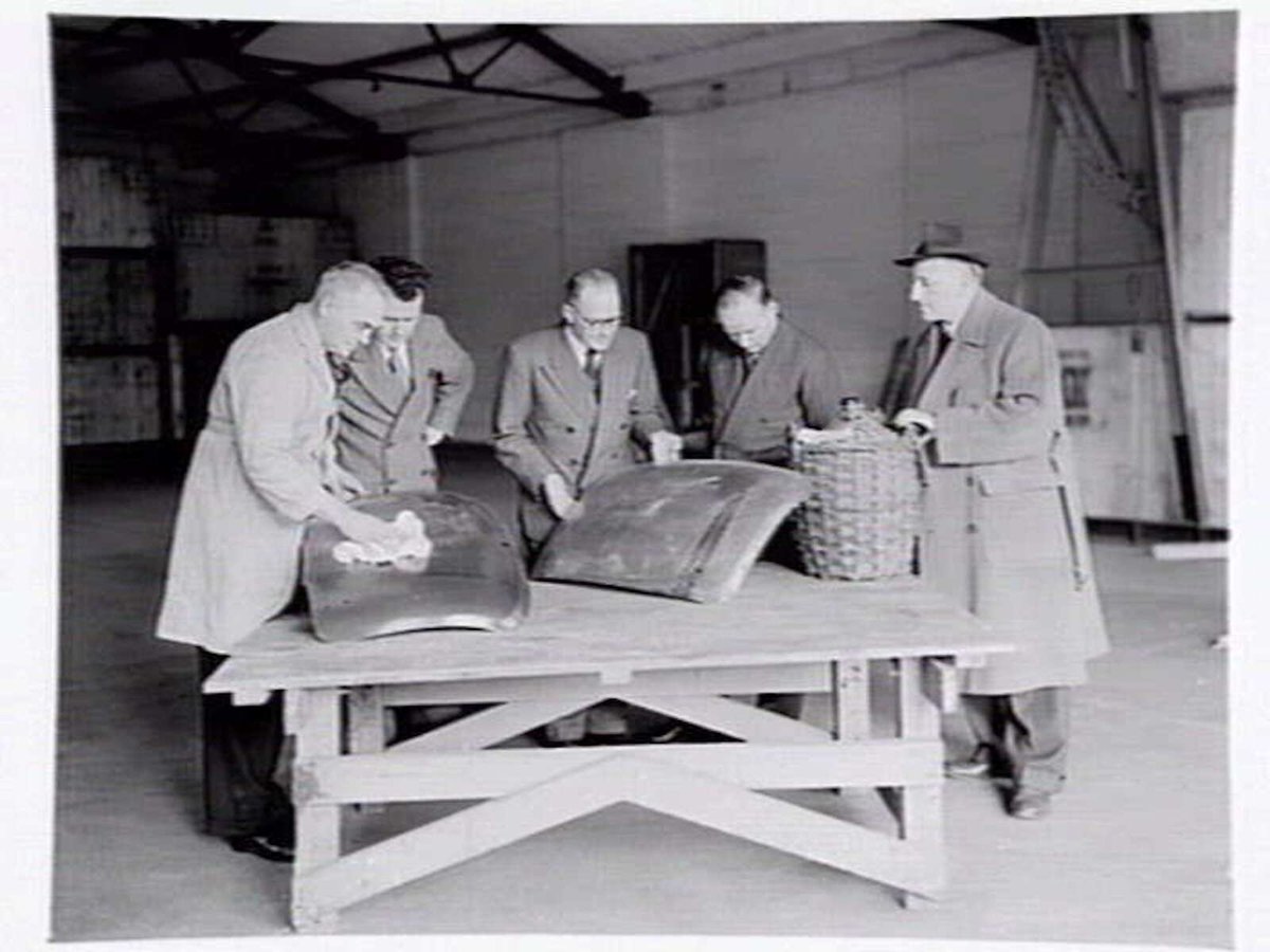 Austin Motor Co., 109 Dudley St., West Melbourne, executives shaking hands, examining car body parts and checking opened crate of body components (1949)