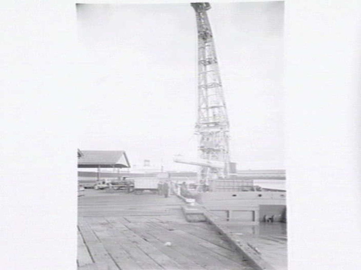 Melbourne Harbour Trust 40 ton floating crane lifting a boiler onto or from a low loader at wharf (1949)