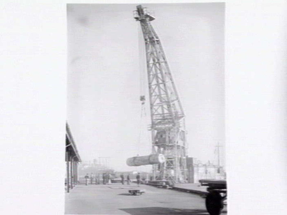 Melbourne Harbour Trust 40 ton floating crane lifting a boiler onto or from a low loader at wharf (1949)