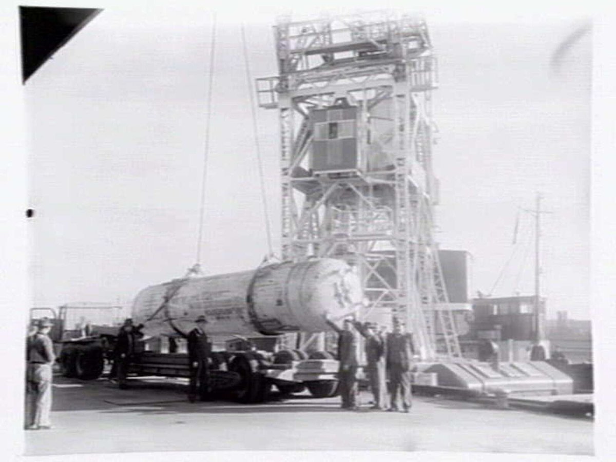 Melbourne Harbour Trust 40 ton floating crane lifting a boiler onto or from a low loader at wharf (1949)