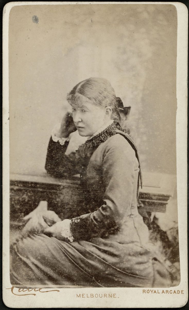Studio portrait of a woman, sitting, to right, three-quarter-length, Royal Arcade, Melbourne, Melbourne City (1876–77)