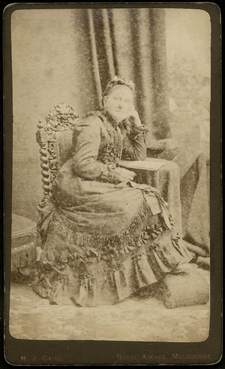 Studio portrait of lady, sitting, to left, whole-length, Royal Arcade, Melbourne, Melbourne City (1876–77)