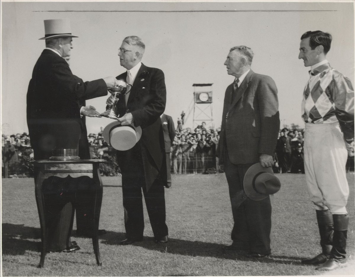 Mr A. E. Underwood, owner of Cup winner, Wodalla, receives the Melbourne Cup from the Governor-General (Sir William Slim), at his right is jockey Jack Purtell and next to him, trainer R. Sinclair, Flemington (1950–56)
