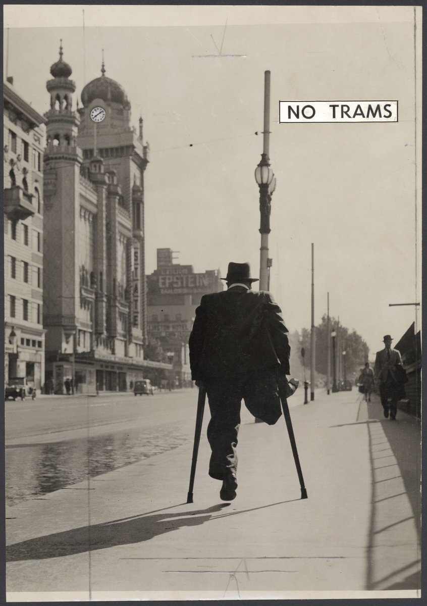 Mr. Harry Cull, liftman from the Treasury Building, walking along Flinders Street during a tram strike, Melbourne City (1948)
