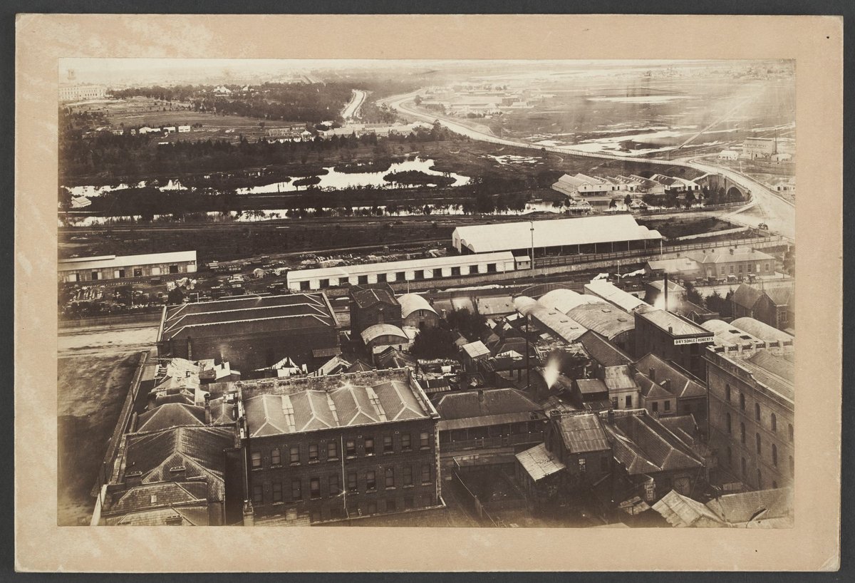 Looking South over roof-tops of Flinders Street, to the Yarra river, Princes Bridge and beyond, Melbourne City (1875)
