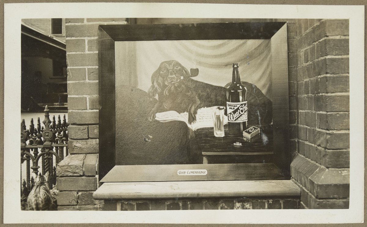 Picture on outer wall, possibly at Bryant & May, Richmond, showing dog smoking pipe, bottle of West End Dinner Ale and packet of Bryant & May matches with caption 'Good Companions' (1920–33)