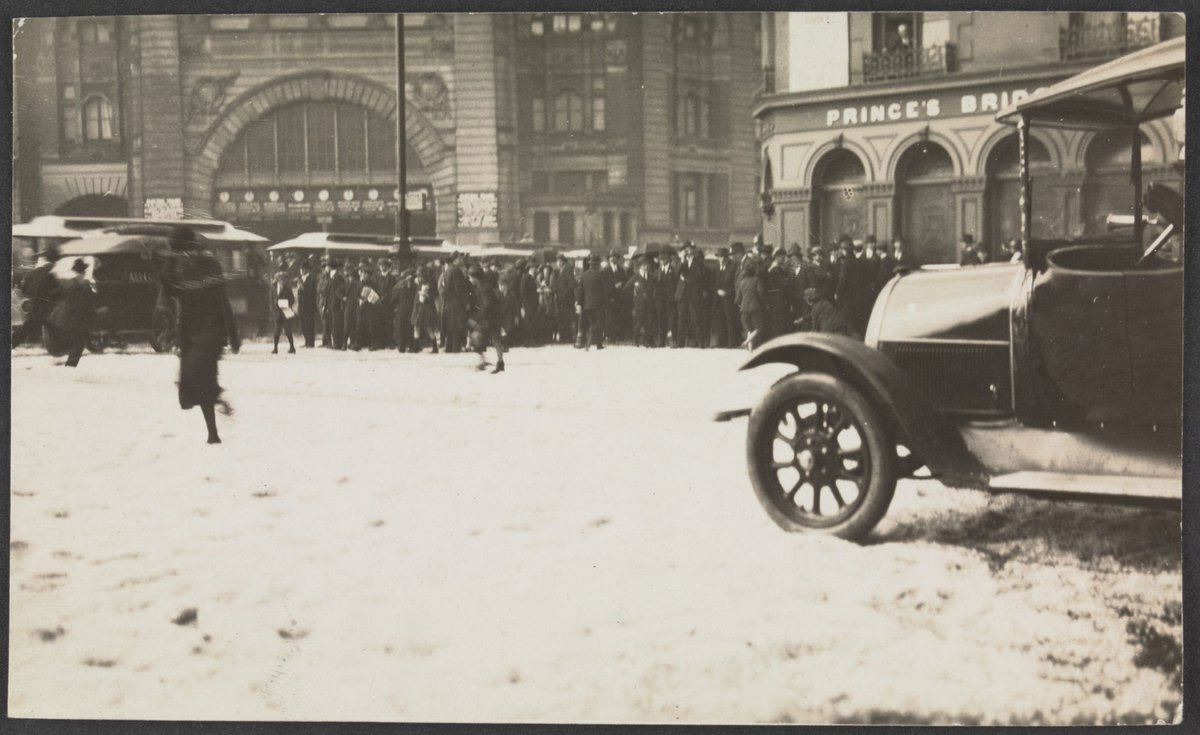 Crowds crossing the intersection of Swanston and Flinders Street towards the station, Melbourne City (1921)